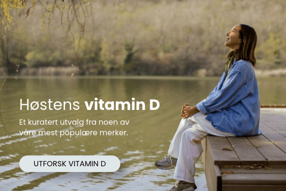 Kvinne sitter ved vannet i høstlandskap med tekst om høstens vitamin D hos vitaminX.